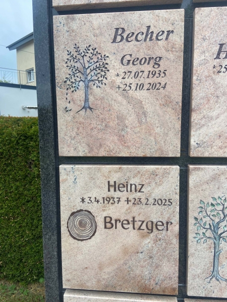 Zwei übereinanderliegene Urnenwandplatten mit in den Stein gehauenen Schriften und verziert