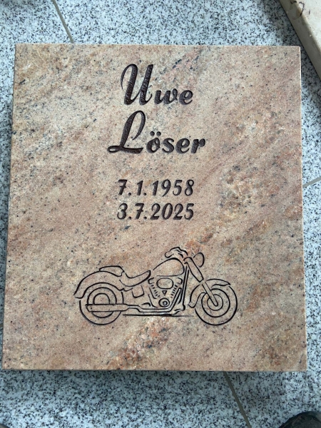 Urnengrabplatte mit in Stein gehauener Schrift und Zieelement Motorrad